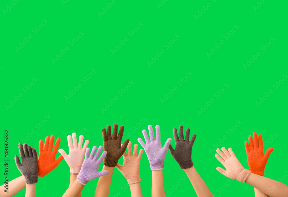 Women in warm gloves on green background