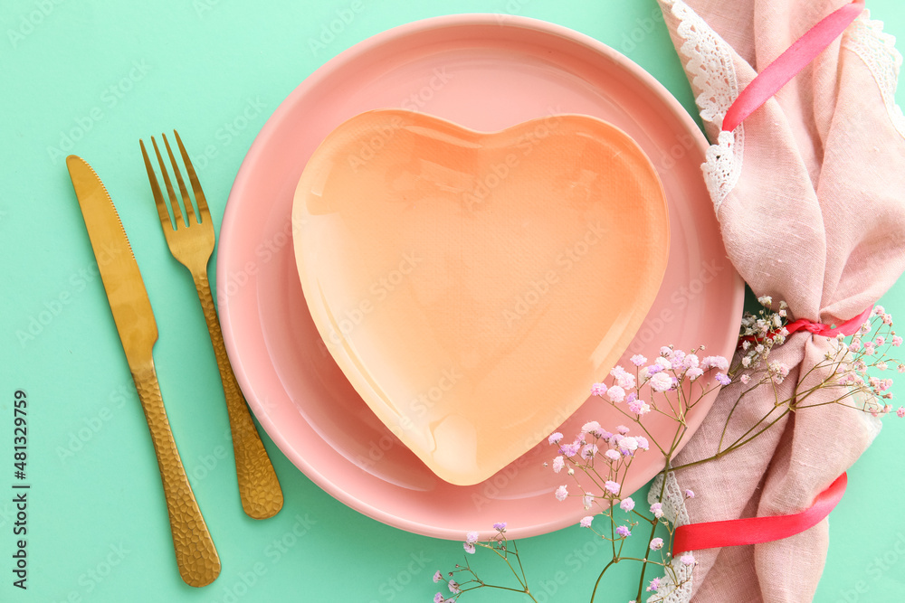 Beautiful table setting for Valentine's Day on green background