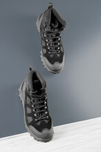 Close-up Pair Black Textile Work Boots For Safe Winter With Steel Toe Walking Down Inclined Smooth Gray Metal Surface.Non-slip Effect Demonstrating Concept.Comfort Flexible Safety Work Wear,roofer.