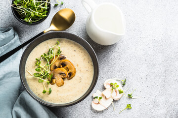 Mushroom Soup on light stone table. Champignon cream soup with herbs. Top view with copy space.