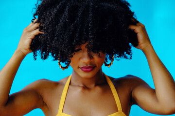 young beautiful woman posing in studio eyes closed hands on hair