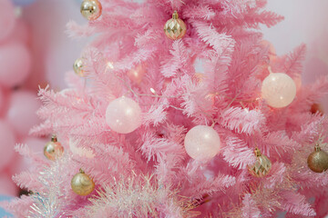 Pink Christmas tree decorated with gold and white balls. Unusual decoration for Christmas. Stylish decorations, background with Christmas theme