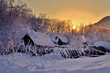 Abandoned houses after snowfall at sunset