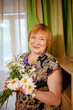 © DariaTrofimova - Old woman with wildflowers at home
