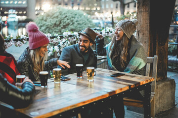 Wall Mural - Young people having fun drinking beer at pub restaurant - Soft focus on center guy face