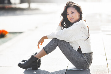 Wall Mural - Beautiful woman outdoors. Pretty lady on urban background. Asian female closeup portrait.