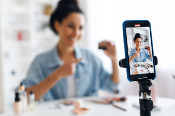 Wall Mural - Unrecognizable Lady Making Video On Cellphone Showing Cosmetics Product Indoor