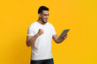 © Prostock-studio - Happy arabic guy with digital tablet celebrating success