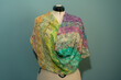 knitted handmade shawl on a white mannequin - multicolored yarn.