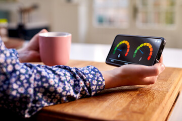 close up of woman holding smart energy meter in kitchen measuring domestic electricity and gas use