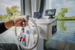 human hand at a houseboat steering wheel