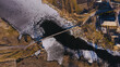 Old, wooden, small bridge on frozen river, sunny chilly day. aerial view