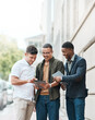 © Nicholas Felix/peopleimages.com - Doing business minus the desk. Shot of a group young businessmen using a digital tablet together against an urban background.