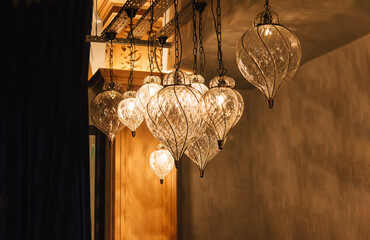 Poster - Glass chandeliers in intricate oriental shape with natural warm yellow light