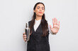 © kues1 - pretty hispanic woman looking serious showing open palm making stop gesture. barman cocktail concept