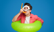 Funny Man In Swimming Goggles And Inflatable Ring In Studio