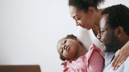 Wall Mural - Confident African parents talking something to their daughter at home