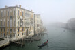 Palästete am Canale Grande von Venedig bei nebeligen Winter Wetter und ein Gondolieri schifft seine Gondel auf dem Wasser.