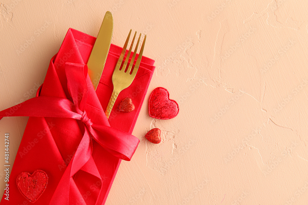 Beautiful cutlery and hearts on beige background