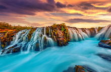 Wonderful Summer View Of Bruarfoss Waterfall, Secluded Spot With Cascading Blue Waters. Great Sunset In Iceland, Europe. Beauty Of Nature Concept Background.