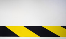 A Black And Yellow Ribbon On A White Isolate. Background With An Enclosing Yellow Stripe.