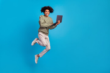 Canvas Print - Full body profile side photo of young man jump use laptop manager agent workshop energetic isolated over blue color background