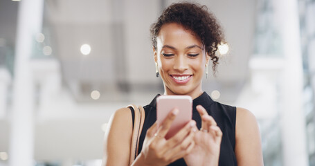 Poster - Staying in touch. Cropped shot of a young businesswoman using a smartphone and waving while walking through a modern office.