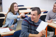Students teasing each other having fun during class in a modern classroom..