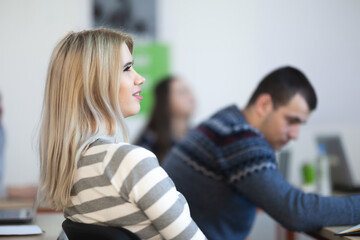 Wall Mural - Young student in modern classroom listening to lecture.