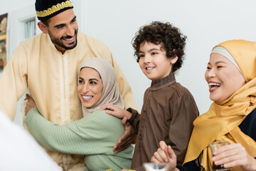 Canvas Print - arabian boy smiling near happy muslim parents and asian grandmother.