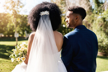 Let's grow old together. Rearview shot of a newlywed young couple standing together outdoors on their wedding day.