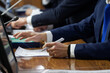 © slexp880 - Hands of men - managers, officials, lawyers or businessmen sitting at table with microphones and monitors. Concept of negotiation, conference and teamwork. Reportage. Selective focus
