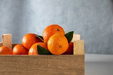 Tangerines In Wooden Box On Wood Background.