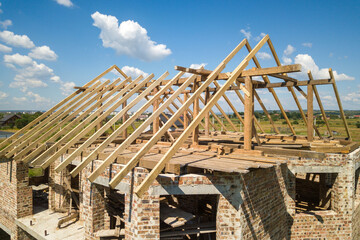 Wall Mural - Aerial view of unfinished house with wooden roof frame structure under construction.