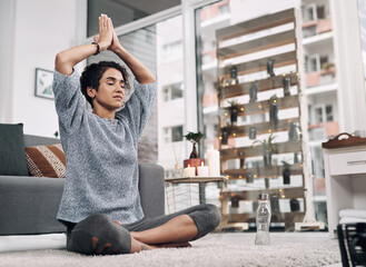 Poster - We earn our peace. Shot of an attractive young woman meditating on her bedroom floor at home.