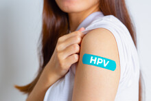 HPV (Human Papillomavirus) Teenager Woman Showing Off An Blue Bandage After Receiving The HPV Vaccine.viruses Some Strains Infect Genitals And Can Cause Cervical Cancer. Woman Health Concept.