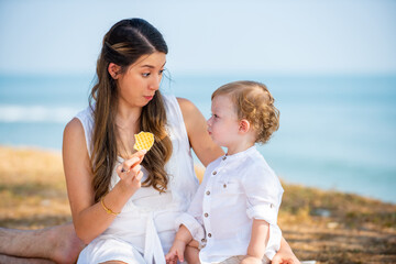 Caucasian couple picnic party with little child boy together on tropical beach. Happy family father and mother with cute baby son enjoy and fun outdoor activity lifestyle on summer travel vacation