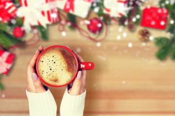 Wall Mural - Surface of cappuccino in cup holding by woman in knitted sweater relaxed sitting on the couch. New year new you