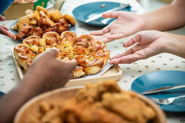 Wall Mural - African family parents and two little daughter eating fried chicken and pizza on table for dinner together. Father and mother and cute child girl kid enjoy eating and sharing a meal together at home