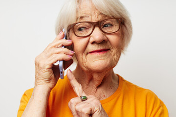 portrait of an old friendly woman in casual t-shirt sunglasses talking on the phone cropped view