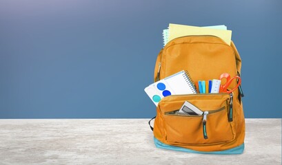 Wall Mural - Backpack with different colorful stationery on the table.