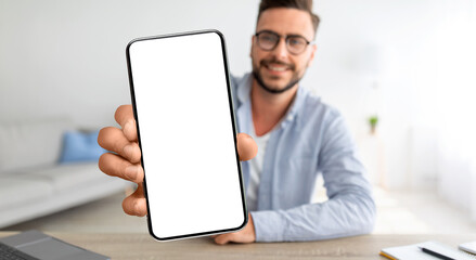 Poster - Online Ad. Smiling Young Guy Demonstrating Smartphone With Blank Screen At Home
