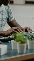 Poster - African american man with headphones listening to music while working from home on computer. Black freelancer dancing and having fun while doing remote work for freelance business