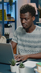 Poster - Business man of african ethnicity using laptop for online remote work. Corporate employee working from home with device, browsing internet for networking job. Professional afro entrepreneur