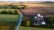 Aerial view of old red wooden farms with road during sunset in Sweden