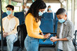 © Prostock-studio - Black woman traveling with kid, using sanitizer in bus