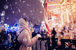 © Parilov - Happy young woman walking in city Christmas market background night holiday bokeh lights. Spending winter vacations in Red square, Moscow, Russia