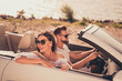 Photo of cheerful young couple rider cabriolet enjoy sunny weather sightseeing travel abroad outdoors