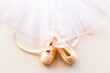 White ballet tutu skirt and beige pointe shoes with ribbon