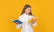 cheerful kid read school homework on yellow background, school